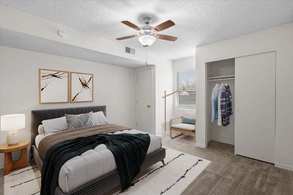 a bedroom with a bed and a ceiling fan at Wind River Lodge, Lenexa, KS