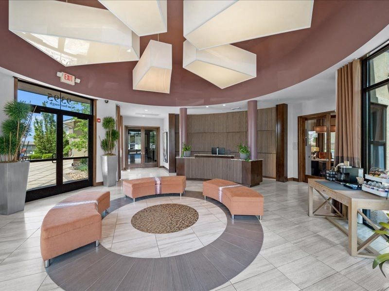 a lobby of a hotel with couches and a reception desk
