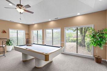 A pool table in a room with a ceiling fan and sliding glass doors. at Coventry Oaks Apartments, Overland Park, KS, 66214