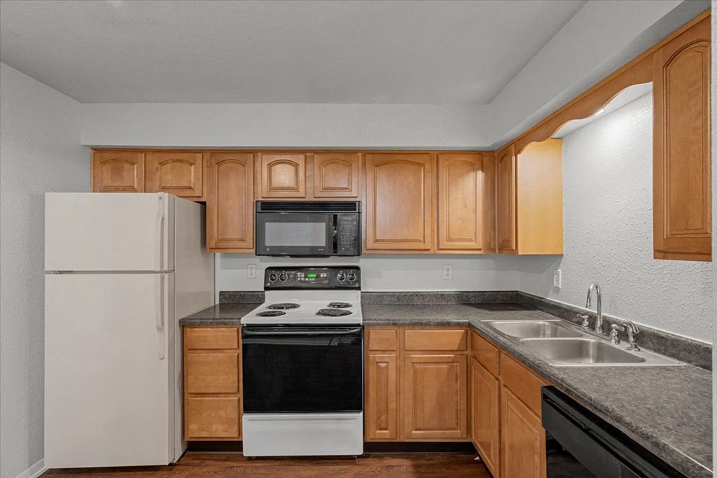 a kitchen with a stove refrigerator and sink