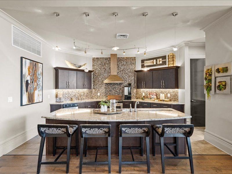 a kitchen with a large island with four chairs