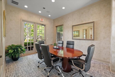 A conference room with a large table and chairs.