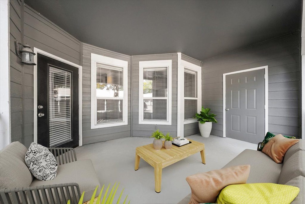 A living room with a grey couch, a wooden coffee table, and a grey wall. at Somerset Oaks Apartment Homes, Olathe, KS