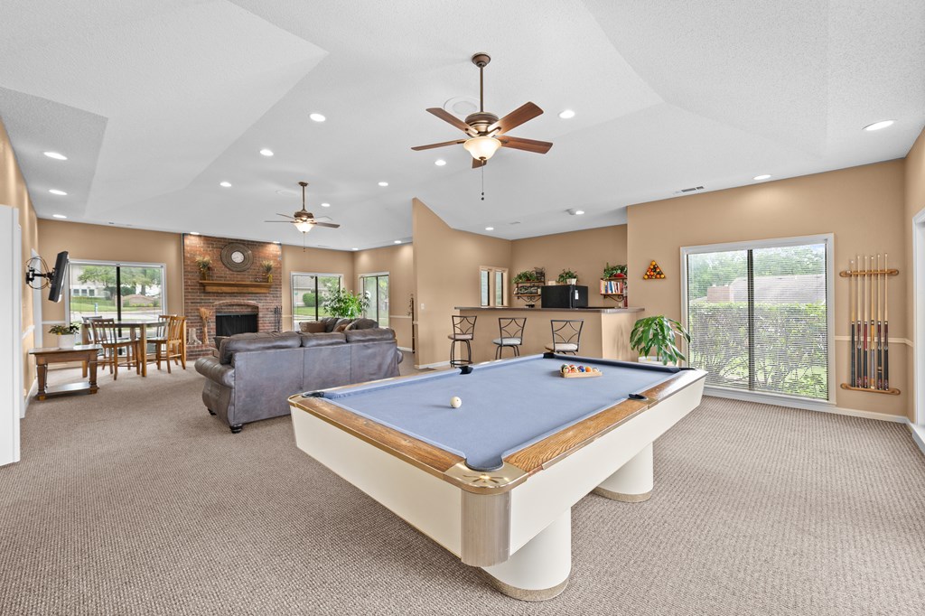 A pool table is in the middle of a room with a ceiling fan. at Coventry Oaks Apartments, Overland Park, Kansas