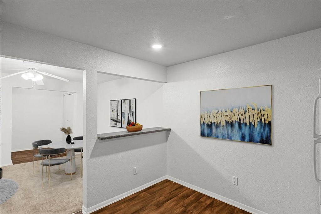 an empty room with a dining room table and a painting on the wall