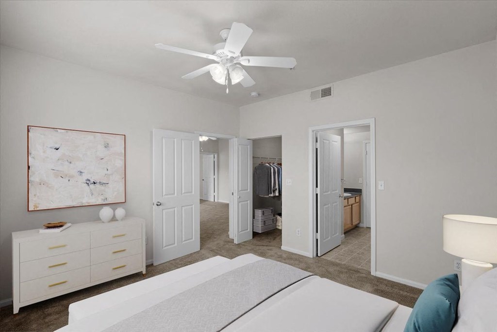a bedroom with a white bed and a ceiling fan