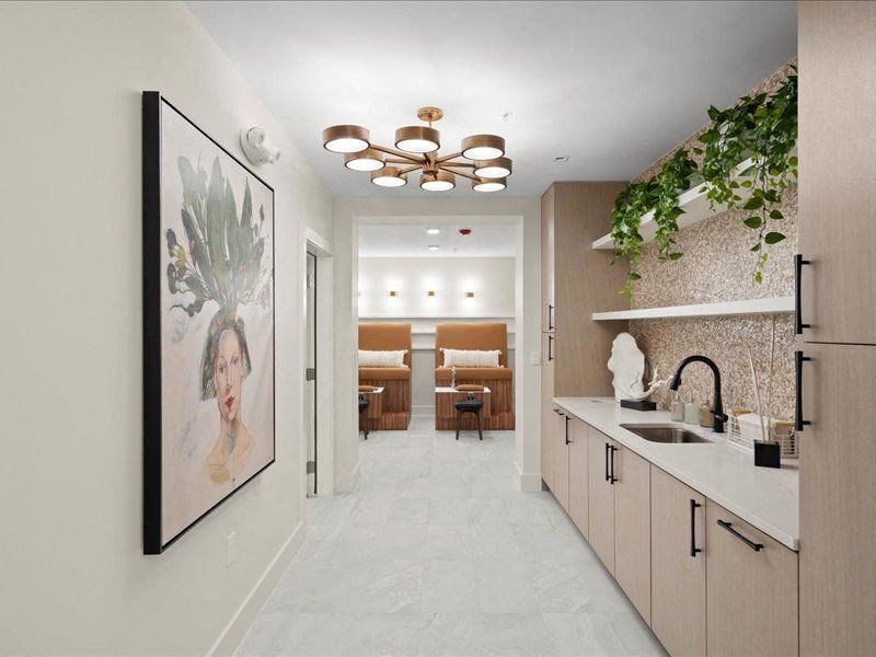 a long white kitchen with a painting on the wall