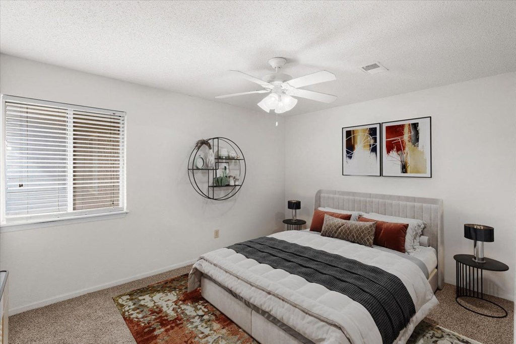 a bedroom with a bed and a ceiling fan