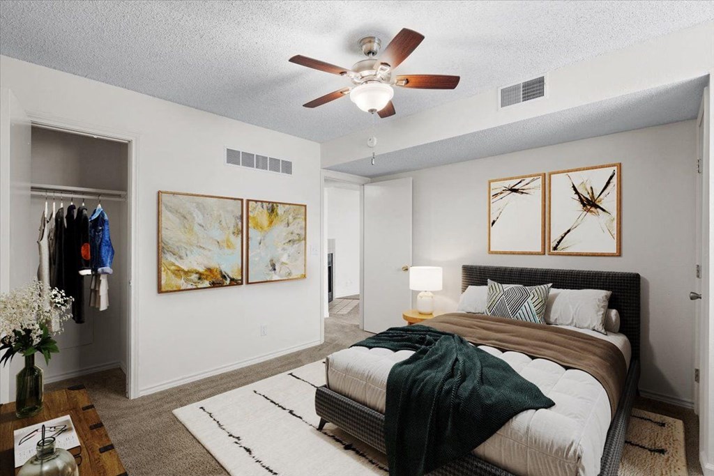 an empty bedroom with a bed and a ceiling fan at Wind River Lodge, Lenexa