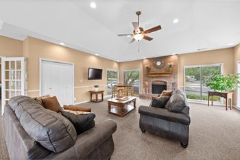 A living room with a grey couch and a fireplace. at Coventry Oaks Apartments, Overland Park 66214