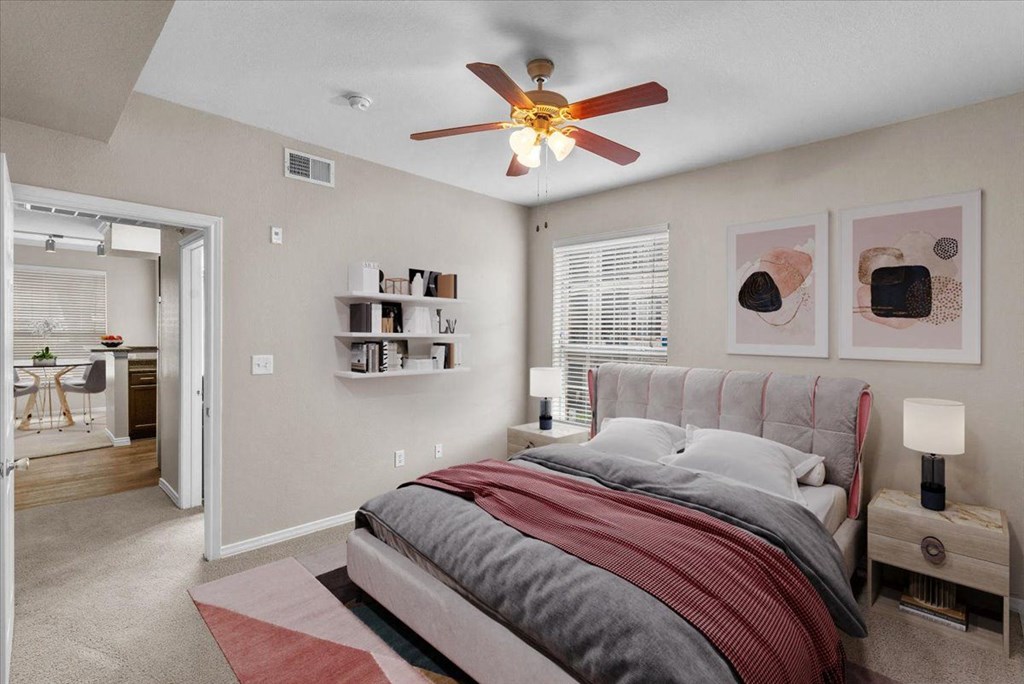 a bedroom with a bed and a ceiling fan at The Clairborne Apartment Homes, Grand Prairie, Texas