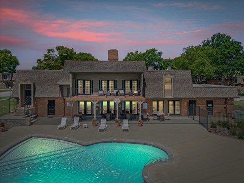 A large house with a pool in front of it.