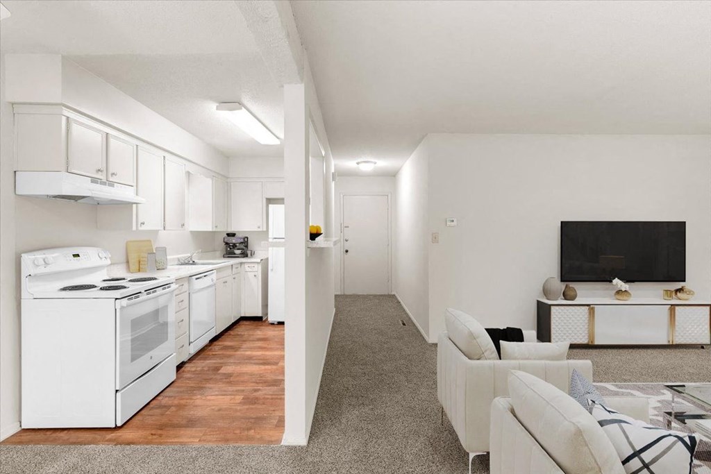 Living room, hallway, and kitchen  at Louisburg Square Apartments & Townhomes, Overland Park, 66212.