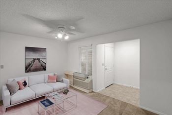 a living room with a white couch and a ceiling fanat Millcreek Woods Apartments, Olathe, Kansas