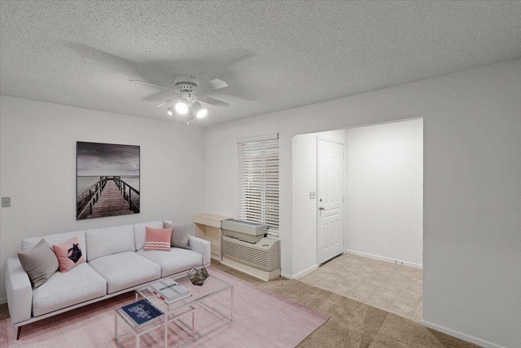 a living room with a white couch and a ceiling fan