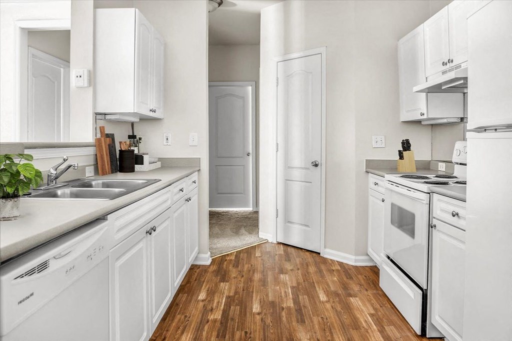 a kitchen with white cabinets and white appliances at Wynnewood Farms Apartments, Overland Park
