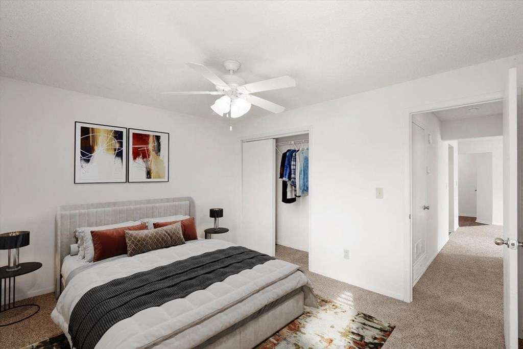 a bedroom with a bed and a ceiling fan