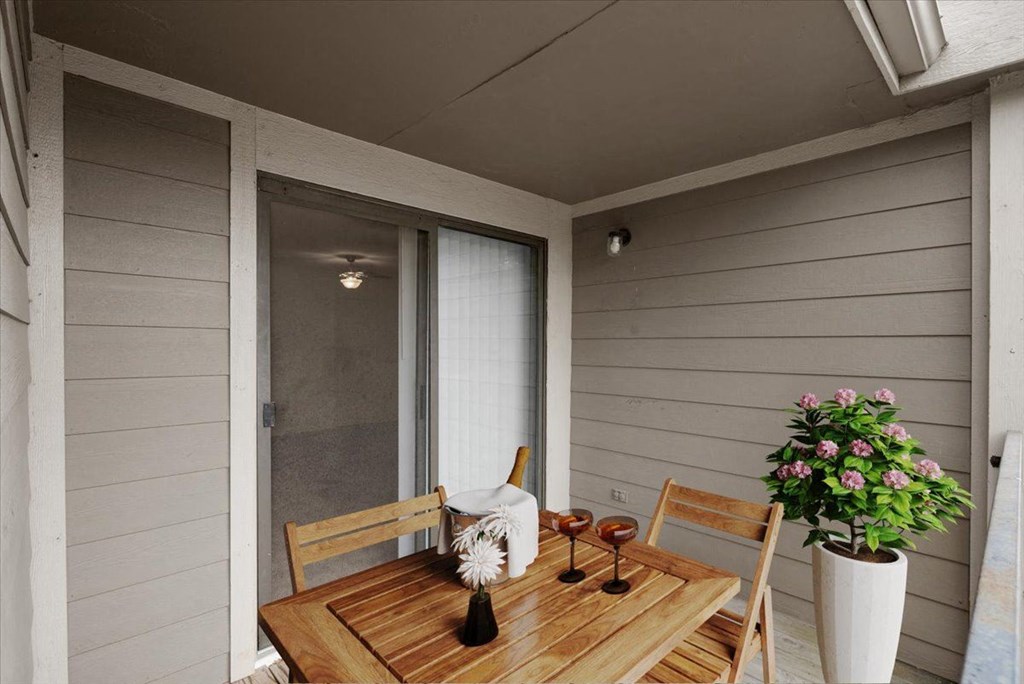 a patio with a wooden table and chairs and a sliding glass door at Wind River Lodge, Kansas