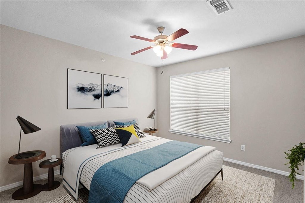 a bedroom with a bed and a ceiling fan at The Clairborne Apartment Homes, Grand Prairie, TX, 75050