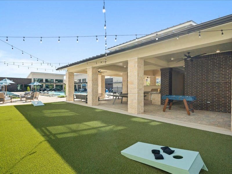 a covered patio with a table and chairs