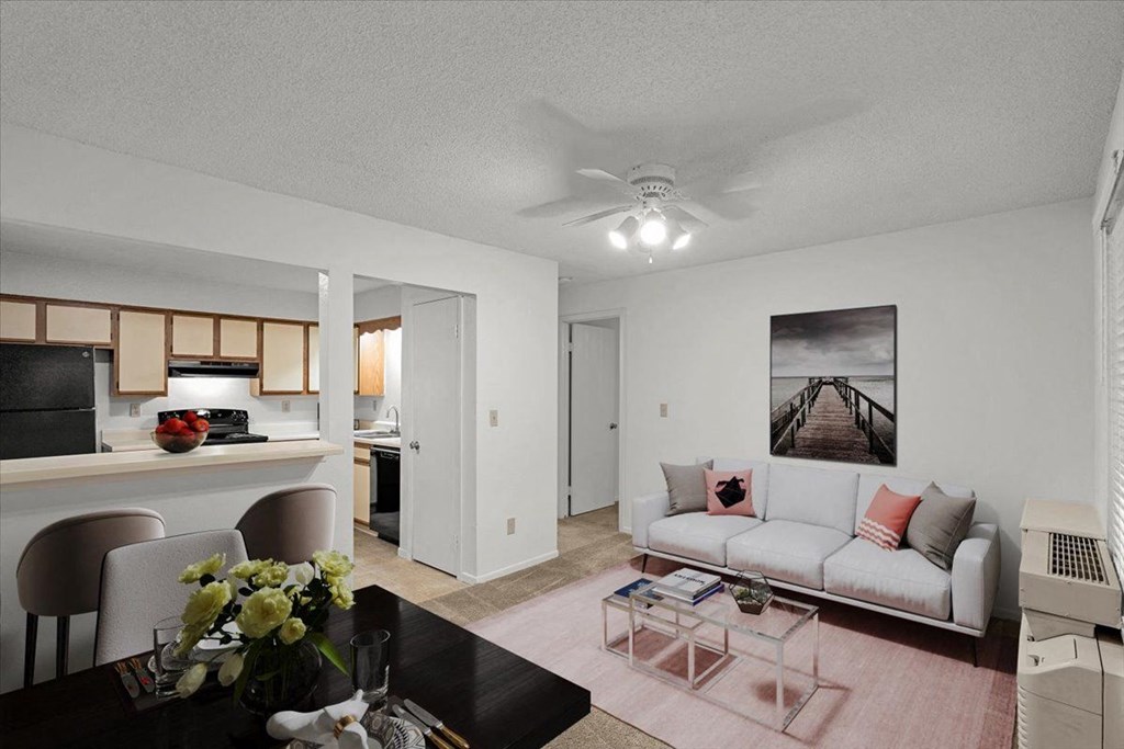a living room and kitchen with a couch and a table