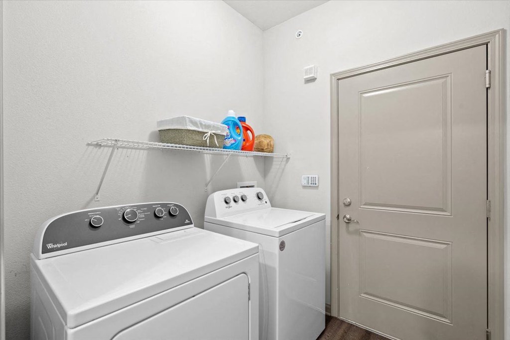 a laundry room with a washer and dryer next to a door