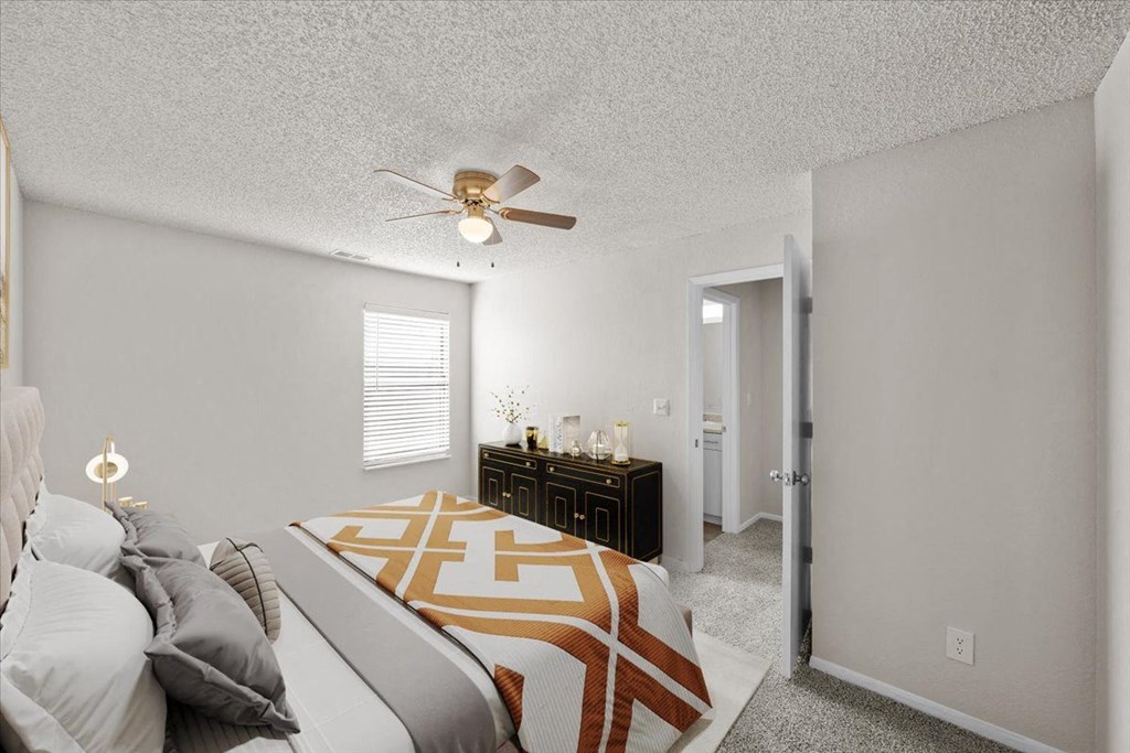 A bedroom with a bed, nightstand, and a ceiling fan at Cloverset Active Adult Apartments, Kansas City, Missouri