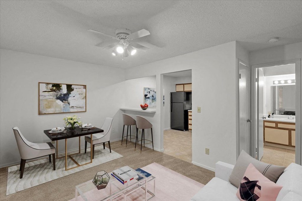 a living room and dining room with a table and a ceiling fan