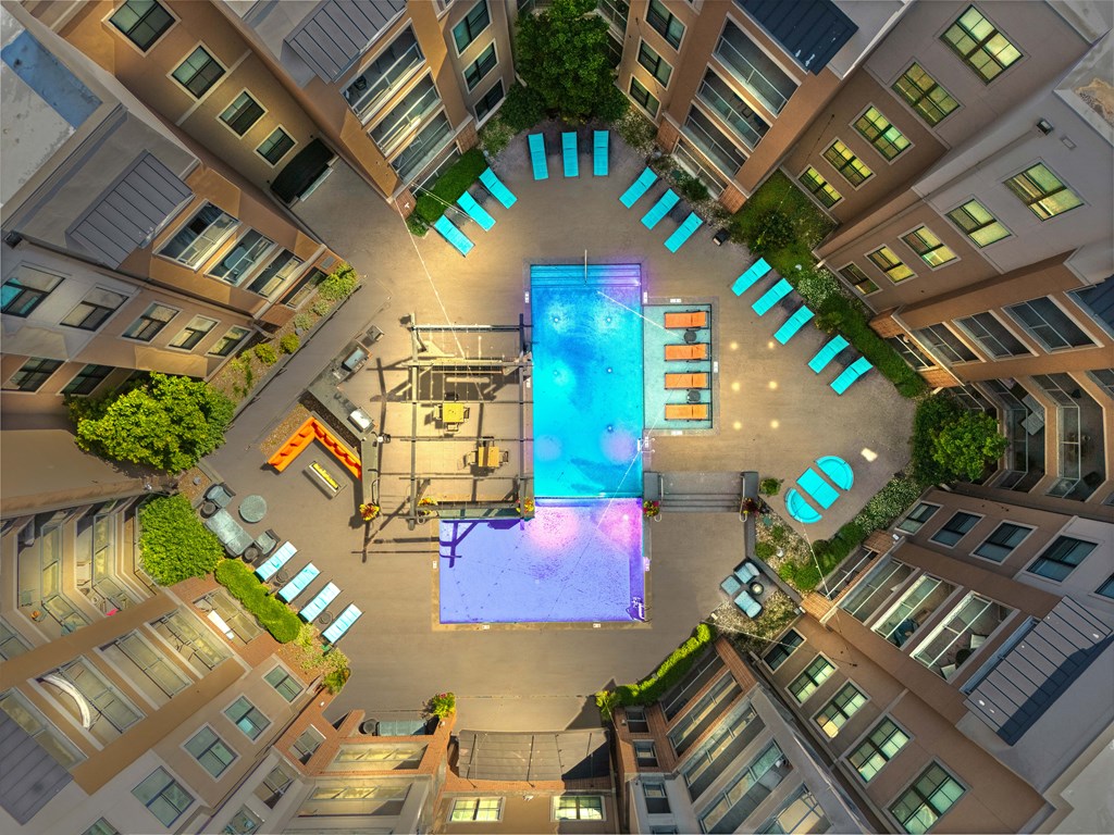 A swimming pool in the middle of a courtyard surrounded by buildings.