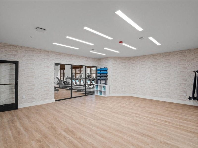 a large room with a wooden floor and mirrored doors