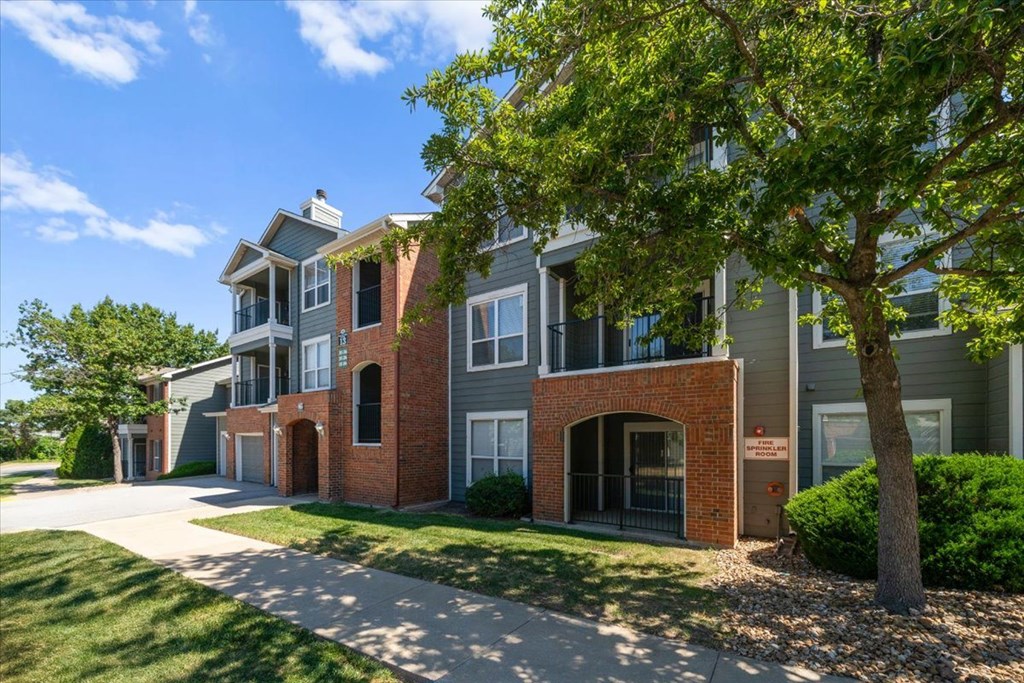 A tree is in front of a building. at Somerset Oaks Apartment Homes, Olathe, KS, 66062