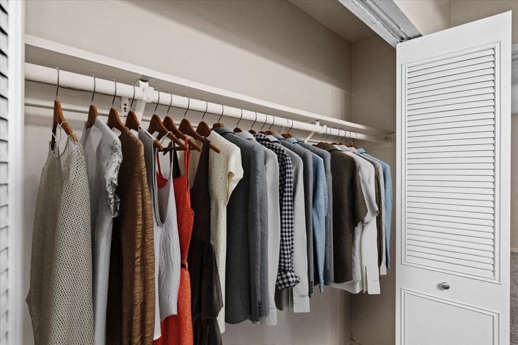 a closet filled with clothes hanging on a rack