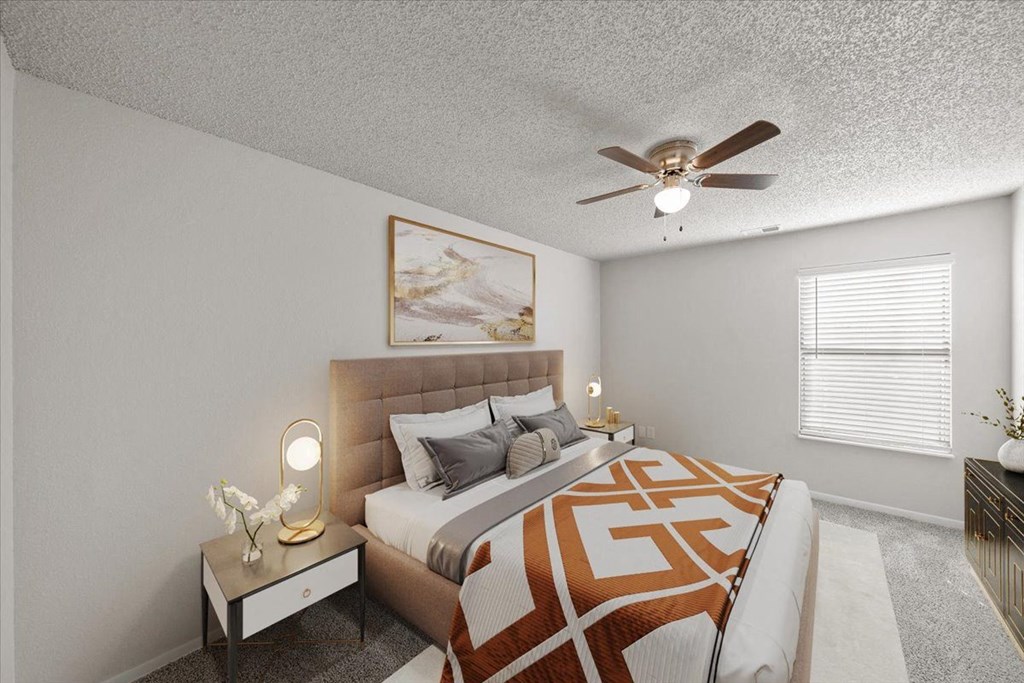 A bedroom with a bed, a nightstand with a lamp, and a painting on the wall.