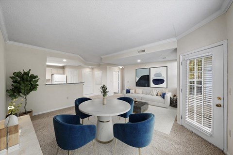 A white and blue living room with a round table and chairs.
