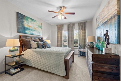 a bedroom with a bed and a ceiling fan at Stonepost Crossing Apartments, Kansas