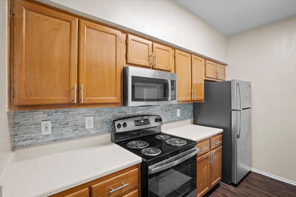 a kitchen with a stove refrigerator and microwave at Creekview Apartment Homes, Dallas, 75254