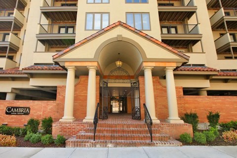 The front entrance of a building named Cambria with a staircase leading up to the door.