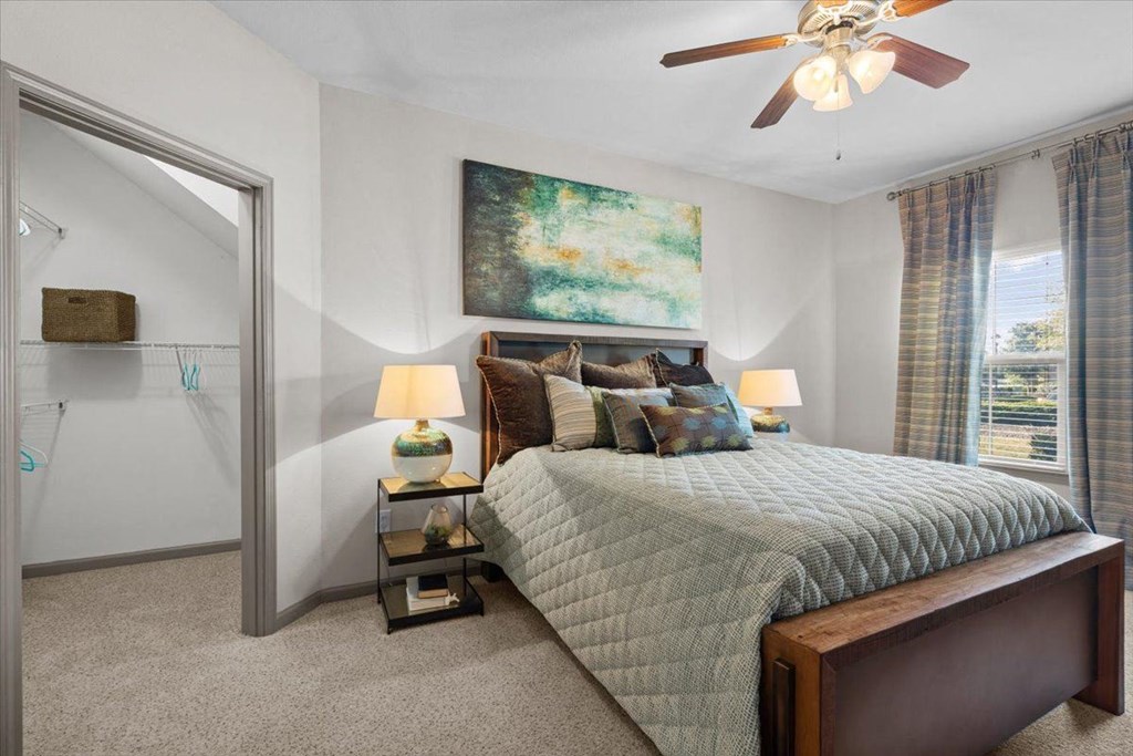 a bedroom with a bed and a ceiling fan