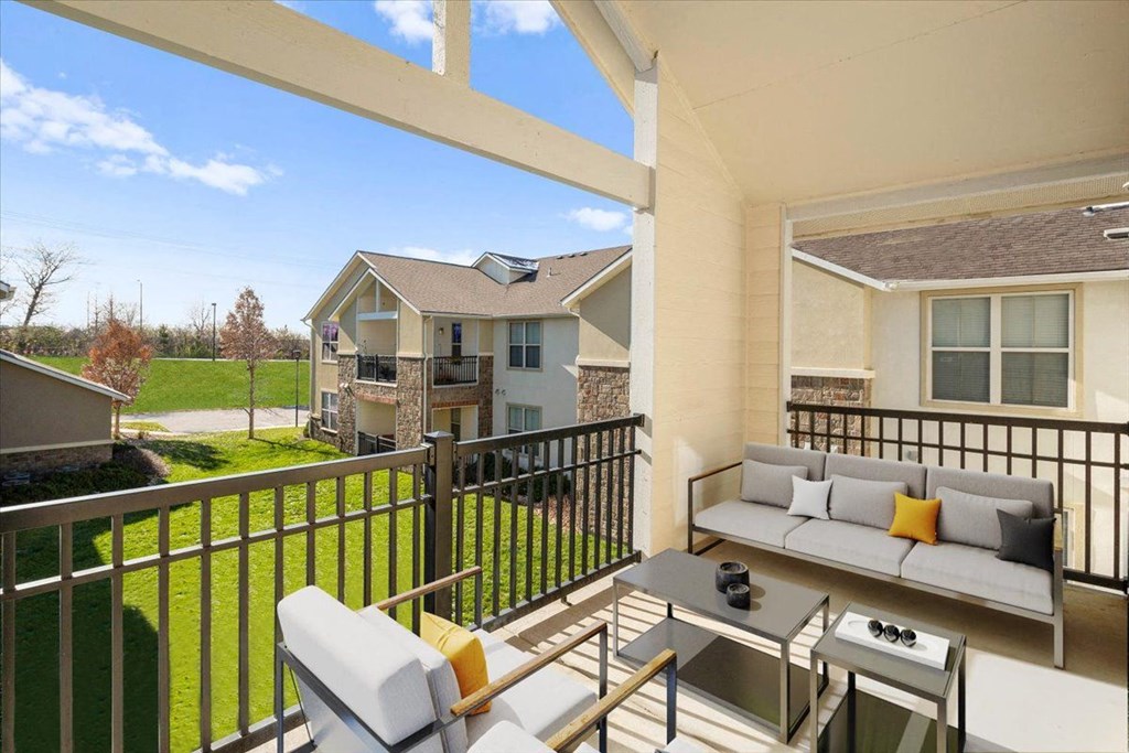 a patio with a couch and a table on a balcony