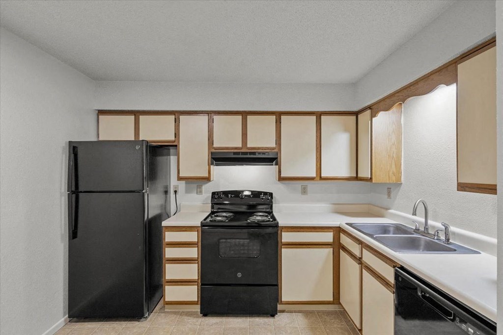 a kitchen with a stove refrigerator and sink