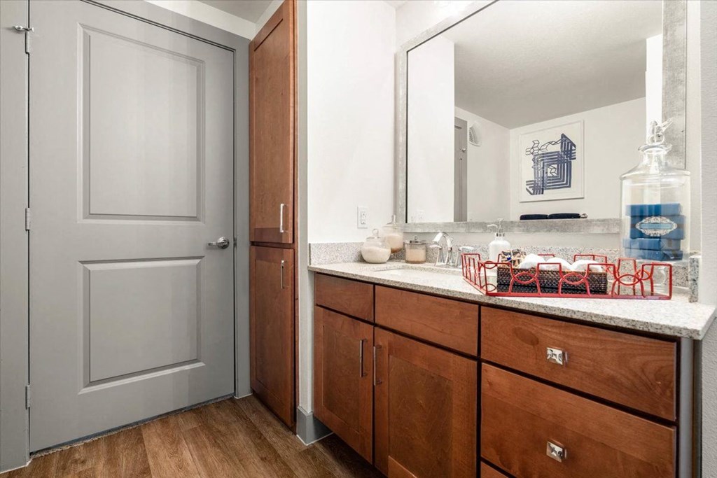 a bathroom with wood cabinets and a large mirror