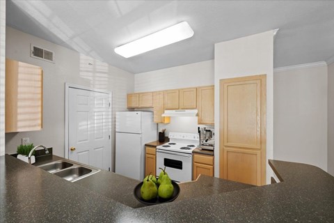 A kitchen with a white stove top oven and a white refrigerator.