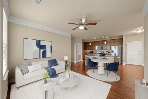 A living room with a white couch and a painting on the wall.