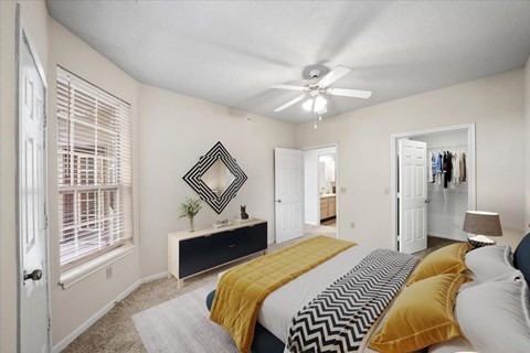 A bedroom with a bed, dresser, and mirror.