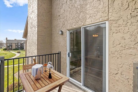 a patio with a table and a sliding glass door at Deerfield Apartments, Olathe, Kansas, 66062