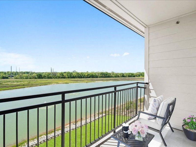 a balcony with two chairs and a table overlooking a river