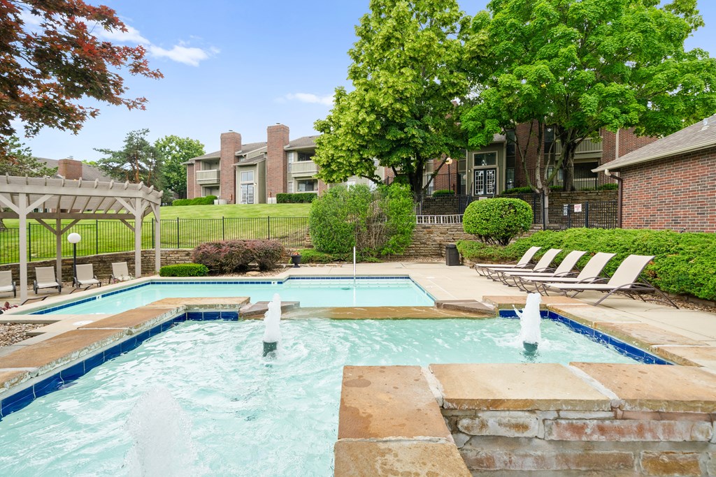 A pool with a waterfall in the middle of it. at Coventry Oaks Apartments, Overland Park