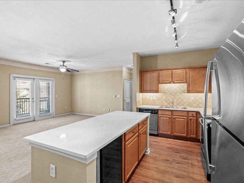 a kitchen with a white counter top and a stainless steel refrigerator
