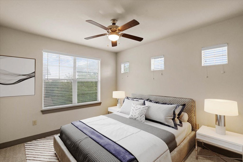 a bedroom with a large bed and a ceiling fan at Cypress at Lewisville Apartment Homes, Texas