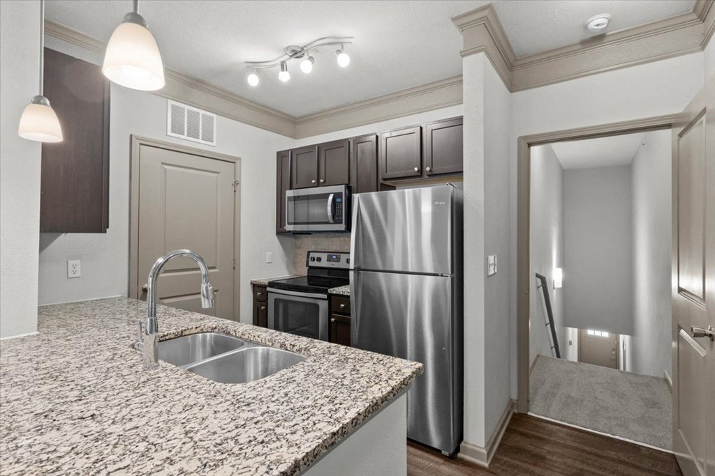 a kitchen with granite countertops and stainless steel appliances